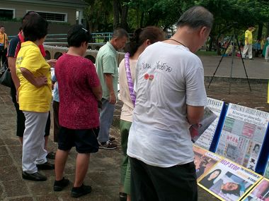 路人仔細閱讀法輪功真相展板