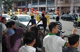 法輪功學員的遊行沿路吸引了許多民眾駐足觀賞。