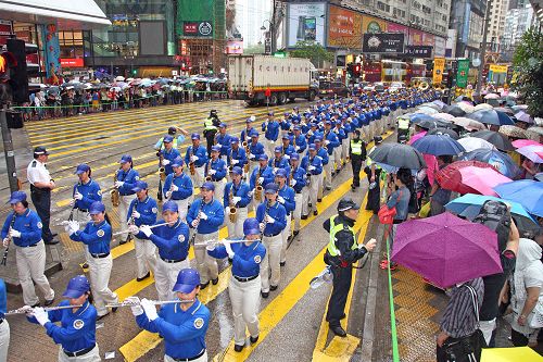 圖7-8.由天國樂團引領的法輪功學員的遊行，在風雨中照樣吸引大批港民及中西遊客冒雨觀看。