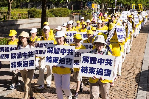 學員們手持「千古奇冤」、「解體中共結束迫害」等橫幅與標語，呼籲解體中共，停止迫害。