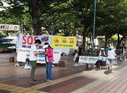 在愛知縣名古屋市最繁華地段之一的榮（Sakae），行人在反中共活摘法輪功學員器官的簽名簿上簽字。