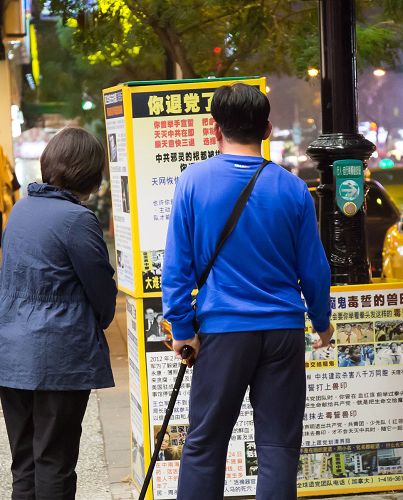 很多大陸遊客把握時間看法輪功真相展板