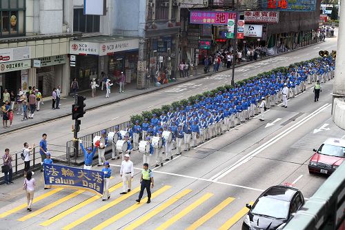 圖6-8：法輪功學員的遊行隊伍由天國樂團前導，吸引道路兩側的廣大民眾駐足圍觀及拍照。