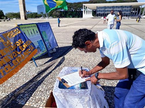 '圖5：了解真相後的巴西人簽名支持制止迫害。'