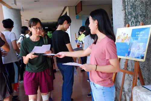 '圖2：開學之際，青年法輪功學員派發法輪功真相傳單'