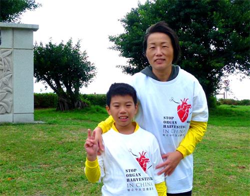 學員家菱和兒子穿上印有「制止中共活摘器官」的上衣，一起向遊客講迫害真相。