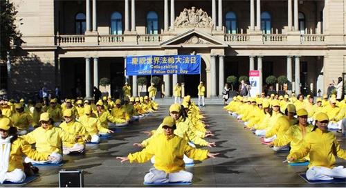 '圖2～3：五月九日，法輪功學員清晨在悉尼市中心海關大樓門前廣場集體大煉功'