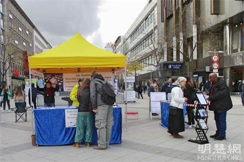 '圖1：二零二一年十月十六日，法輪功學員在德國漢諾威（Hannover）中心火車站附近的步行街舉辦了信息日活動，向當地居民介紹法輪功的真相。'