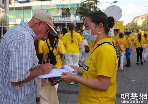 圖8 - 13：遊行隊伍吸引路人駐足，在了解法輪功真相後，他們紛紛簽名支持法輪功