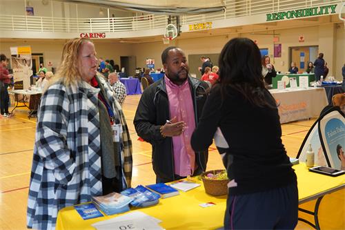 圖1～2：二零二二年三月二十七日，法輪功學員在新澤西州勞雷爾山市（Mount Laurel）的首屆社區資源博覽會上設立展位，向人們介紹法輪功。（法輪功學員提供）