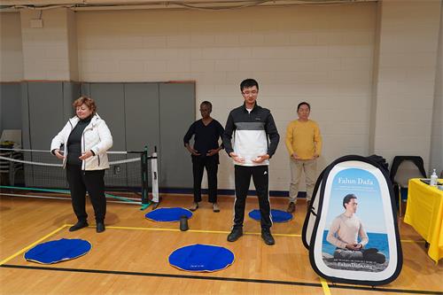 圖4：法輪功學員在展位旁做功法演示，並提供免費教功。（法輪功學員提供）