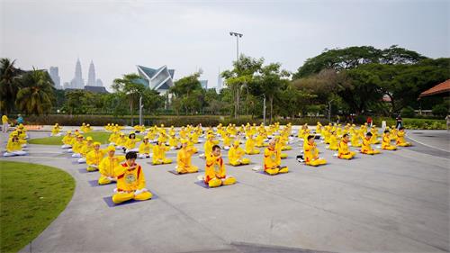 '圖2～3：馬來西亞部份法輪功學員在吉隆坡著名的休閒公園──蒂蒂旺沙湖濱公園（Titiwangsa Lake Garden）廣場前進行集體煉功，場面莊嚴祥和。'