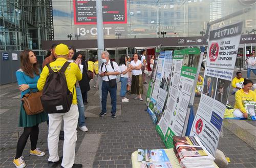 圖3～5：人們觀看展板，向法輪功學員了解真相。