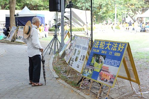 圖12：老先生駐足在展板前關心自焚偽案真相