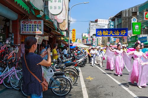 洪法隊伍中美麗的仙女隊展現大法美好，普受民眾喜愛，紛紛高舉著手機拍照留念。