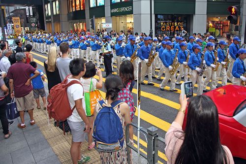 圖4：民眾喜見法輪功遊行隊伍，紛紛拿起手機、相機拍照留念。