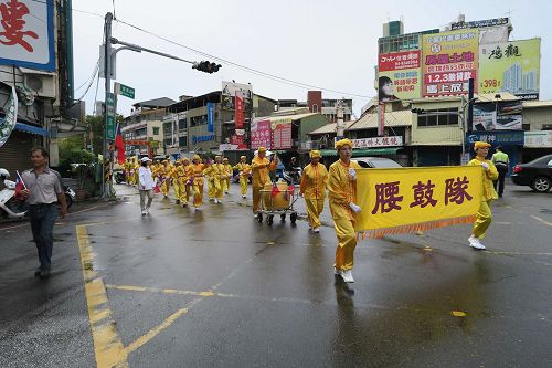 '圖2：腰鼓隊精神抖擻的揮動鼓棒前進。'