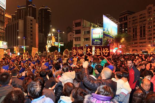 高雄慶元宵遊行活動，兩側的觀眾被天國樂團盛大的陣容震撼，有群眾看到法輪功天國樂團隊伍來了，就高舉雙手鼓掌，也有群眾高喊「法輪大法好」。