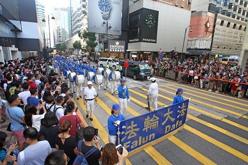 '圖4：由法輪功學員組成的隊伍，在天國樂團引領下，遊行九龍區旺角、佐敦，再到尖沙咀廣東道，抵達終點天星碼頭。沿途吸引港民及中西旅客觀看。'