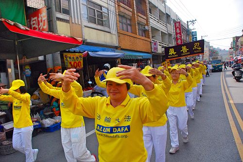 圖2：法輪功學員在校慶踩街中表演法輪功功法。