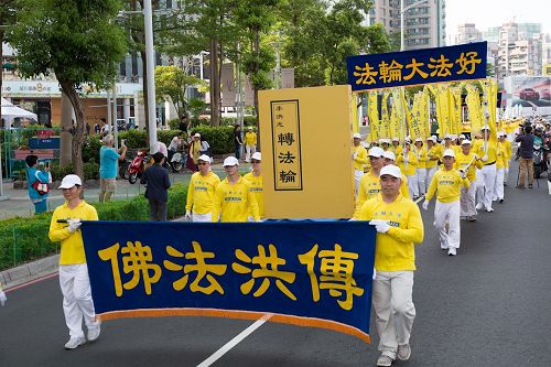 '圖3：二零一七年高雄法輪功學員集會遊行，提前「慶祝世界法輪大法日」，展開指導修煉的《轉法輪》巨型模型。'