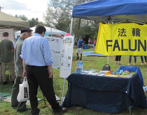 '圖：民眾在展位前閱讀法輪功真相展板'