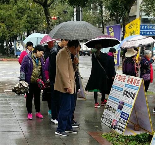 '圖1～2：國父紀念館前，大陸遊客認真閱讀法輪功真相展板'