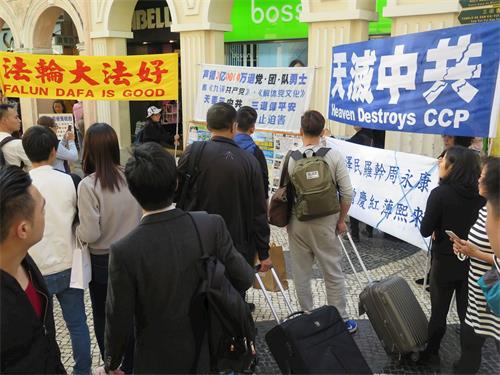 '圖2：二零一八年三月十一日下午，澳門法輪功學員在市中心步行街舉行集會，聲援三億中國人認清中共的邪惡本質，聲明退出共產黨、共青團及少先隊（簡稱三退）。'