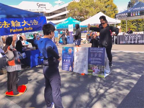 '圖5：法輪功學員在金寶鎮主街擺設展位，展示法輪功五套功法'