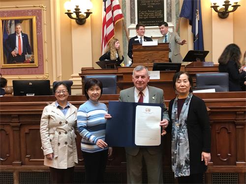 圖2：二零二二年三月八日，共和黨議員約翰﹒阿沃利（John Avoli，右二）在州府大樓眾議院會議廳為法輪功學員頒發決議案。(弗吉尼亞法輪功學員提供）