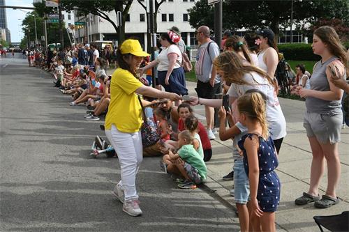 『圖5～6：跟隨遊行隊伍的法輪功學員向民眾發放真相傳單並介紹法輪功』