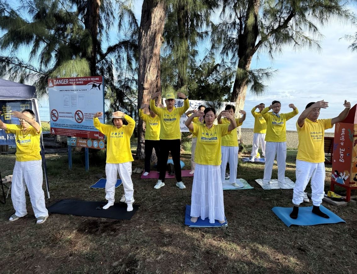 '圖1:留尼汪島法輪功學員在聖保羅市中心設立的信息展台前展示功法'