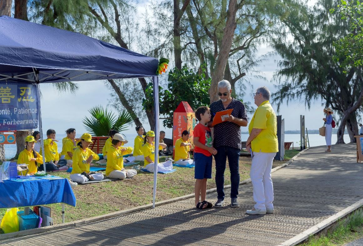 '圖2:留尼汪島法輪功學員在向路人徵簽停止迫害'